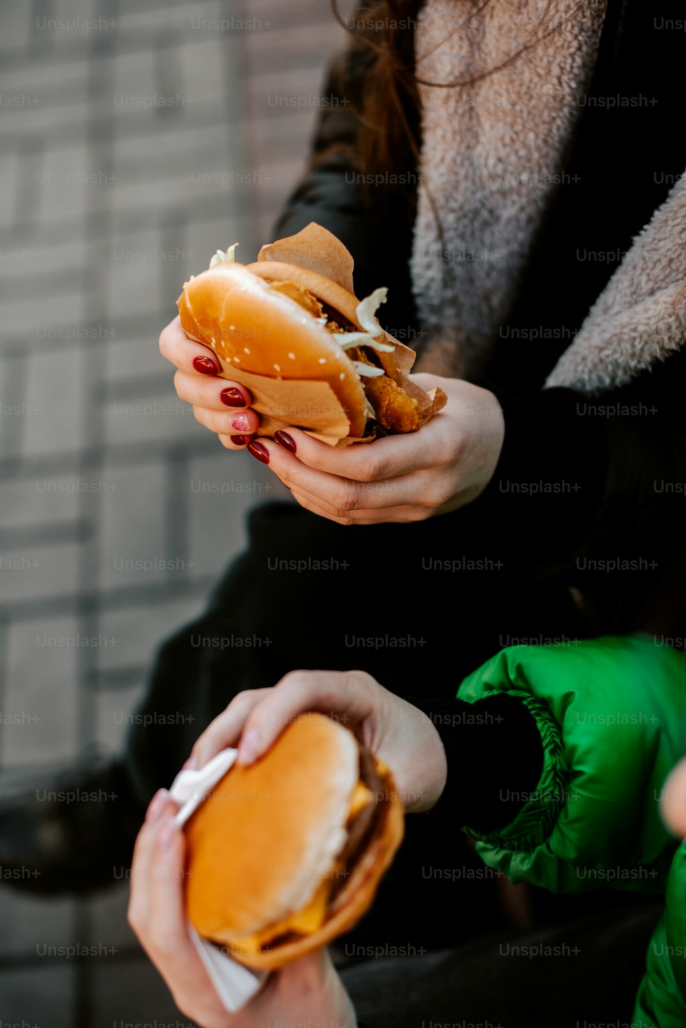 Una mujer sosteniendo un sándwich en sus manos