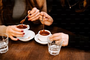 a couple of people sitting at a table with cups of coffee