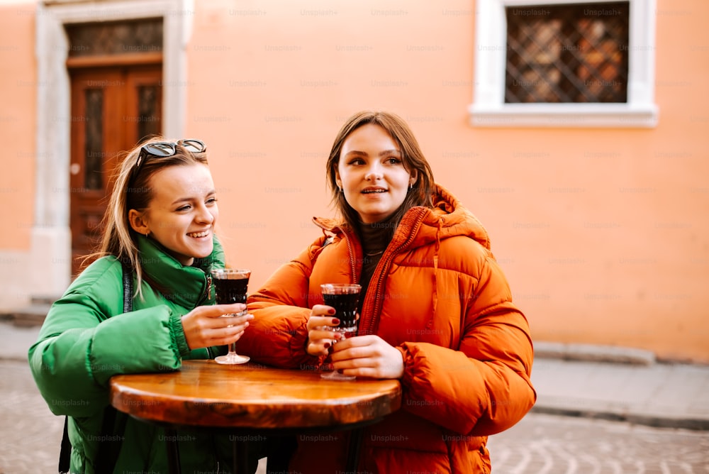 two women standing next to each other holding wine glasses