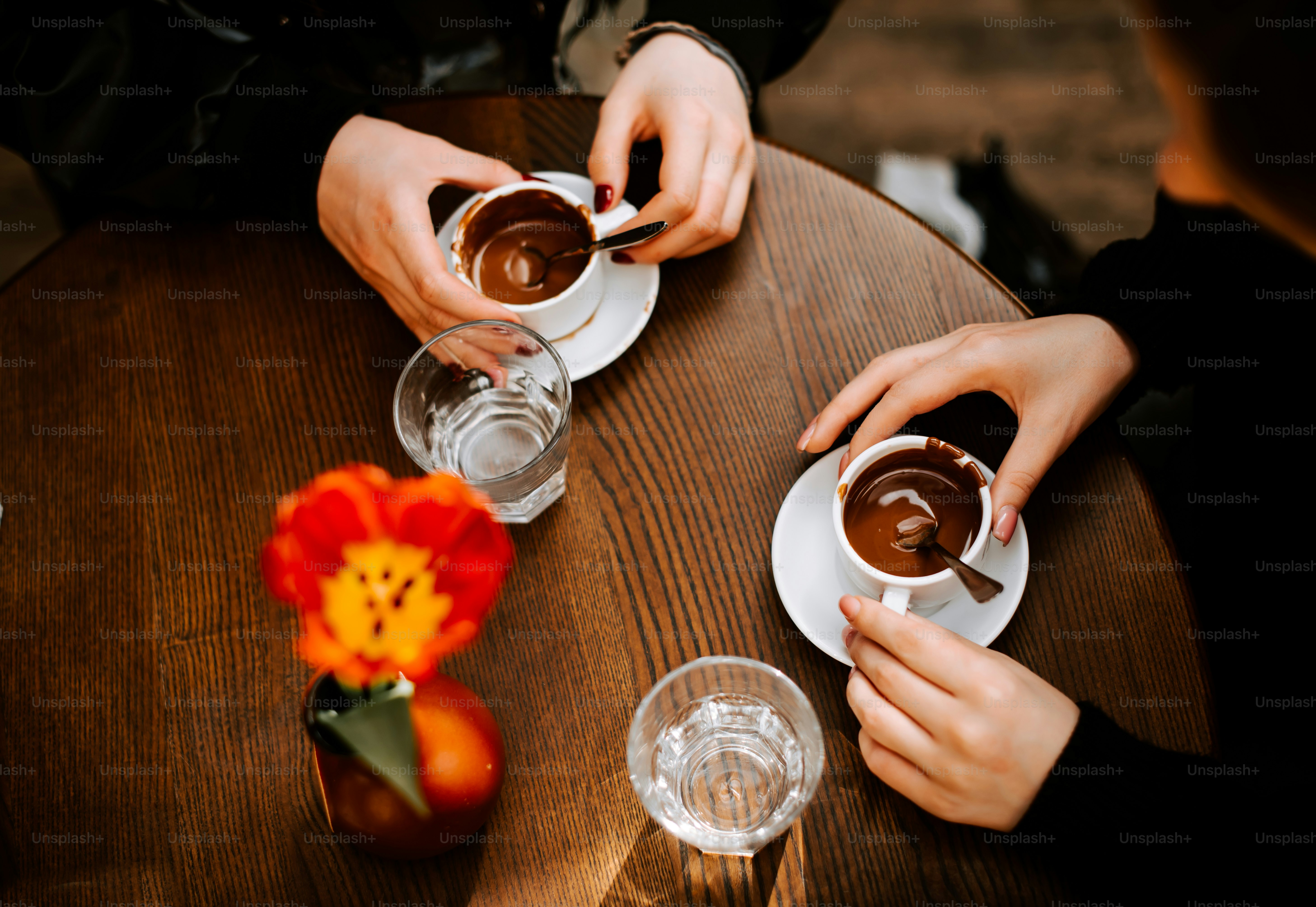 a couple of people sitting at a table with cups of coffee