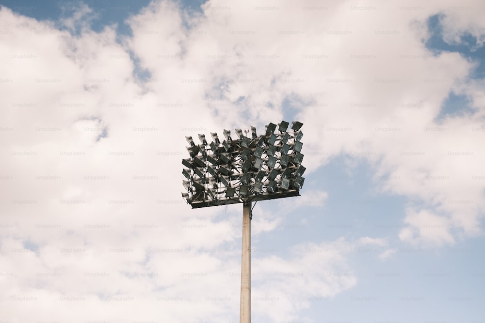 a large crowd of people sitting on top of a tall pole