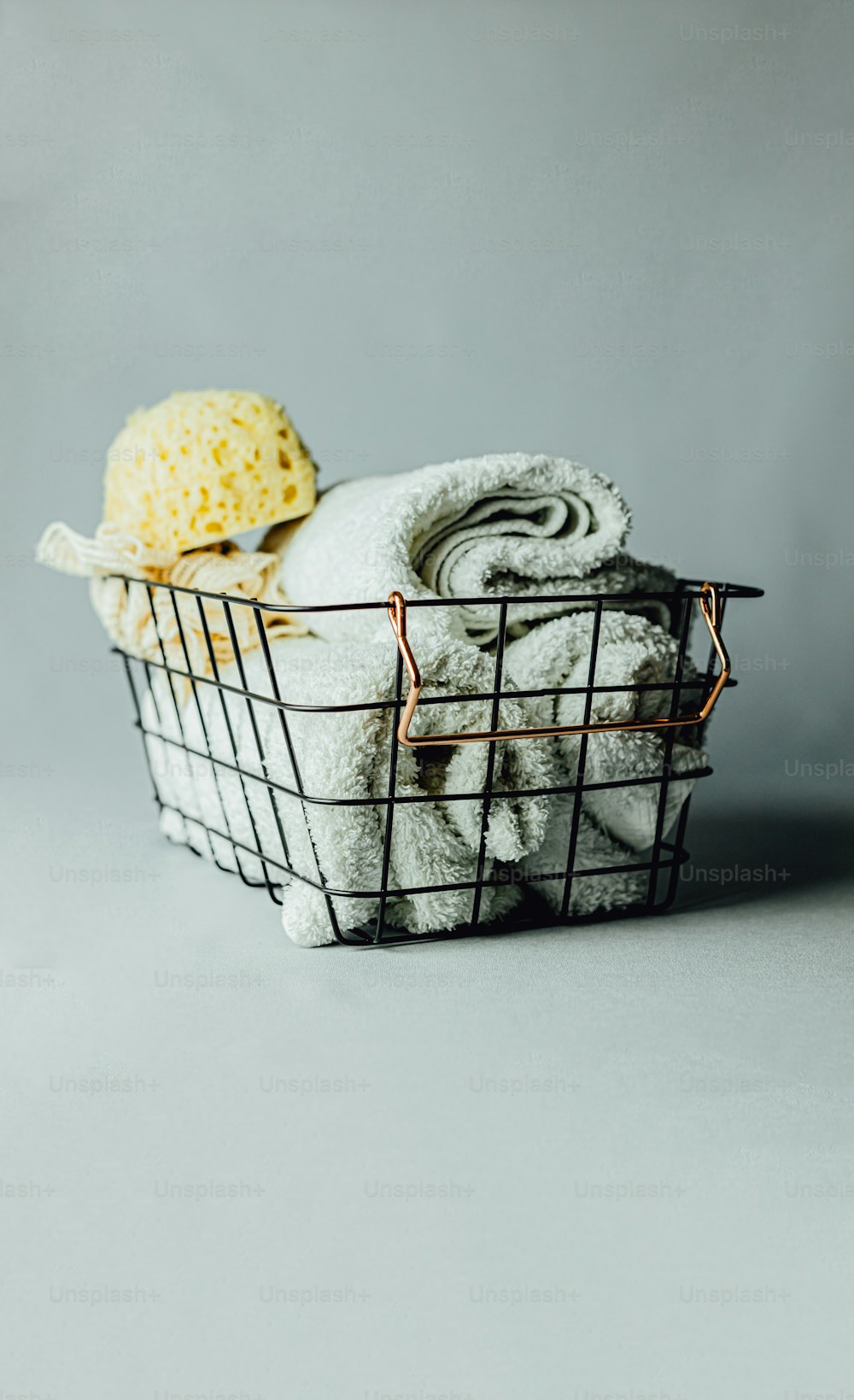 a basket filled with towels and a ball of yarn