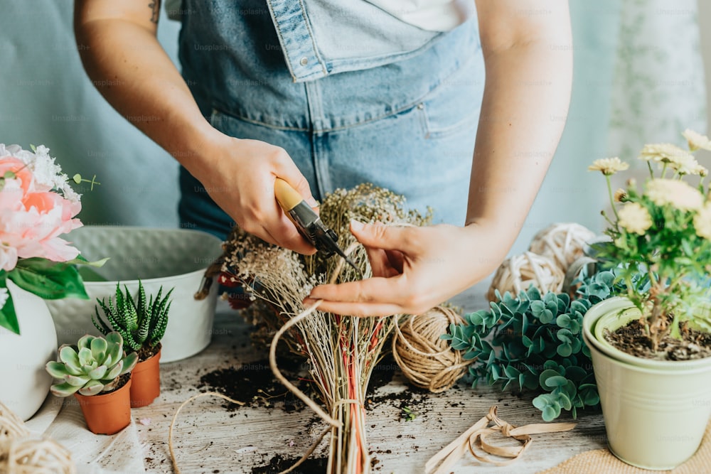 a person in overalls working on a flower arrangement