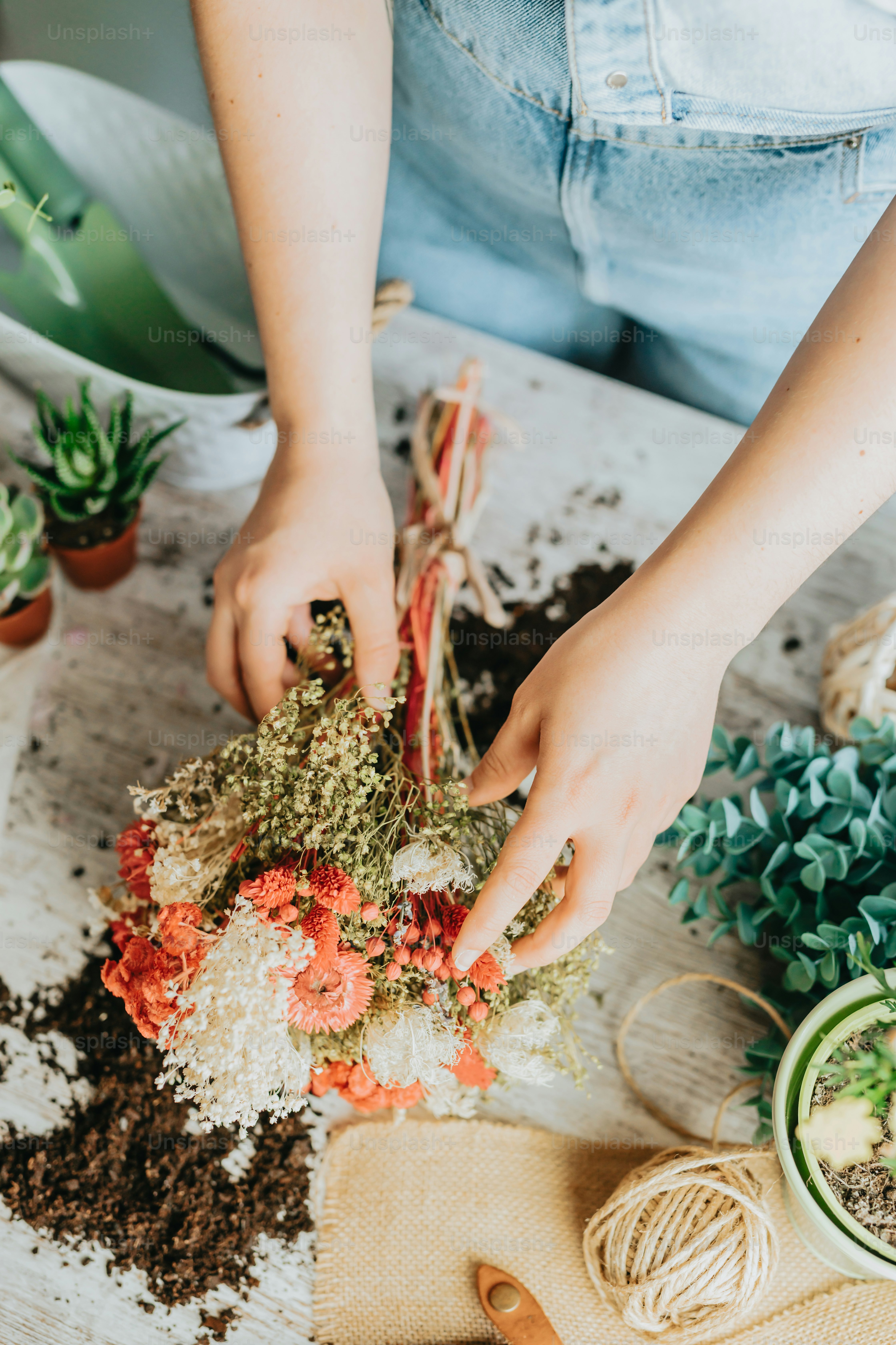 Una mujer está arreglando flores en una mesa