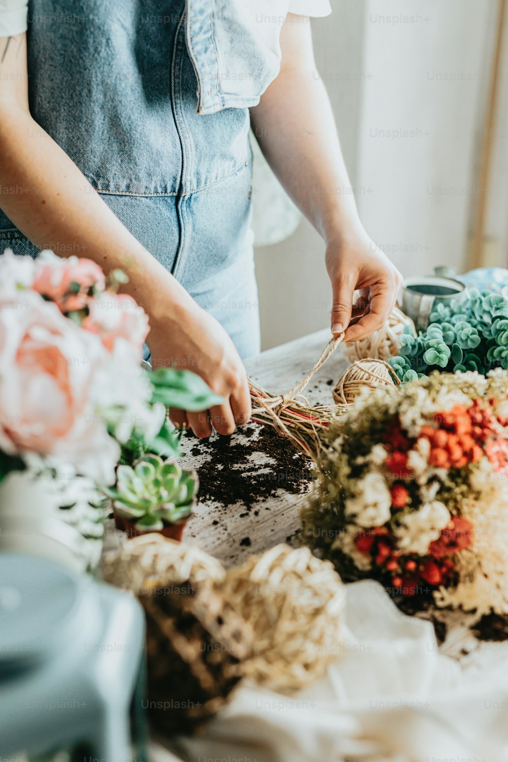 uma mulher está organizando flores em uma mesa