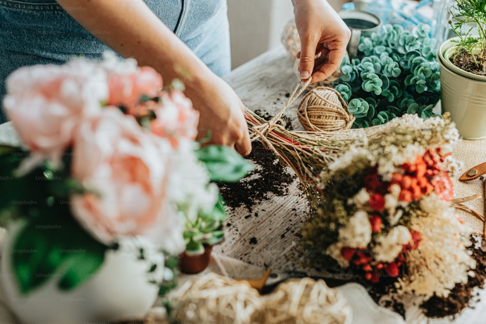 a woman is arranging flowers on a table