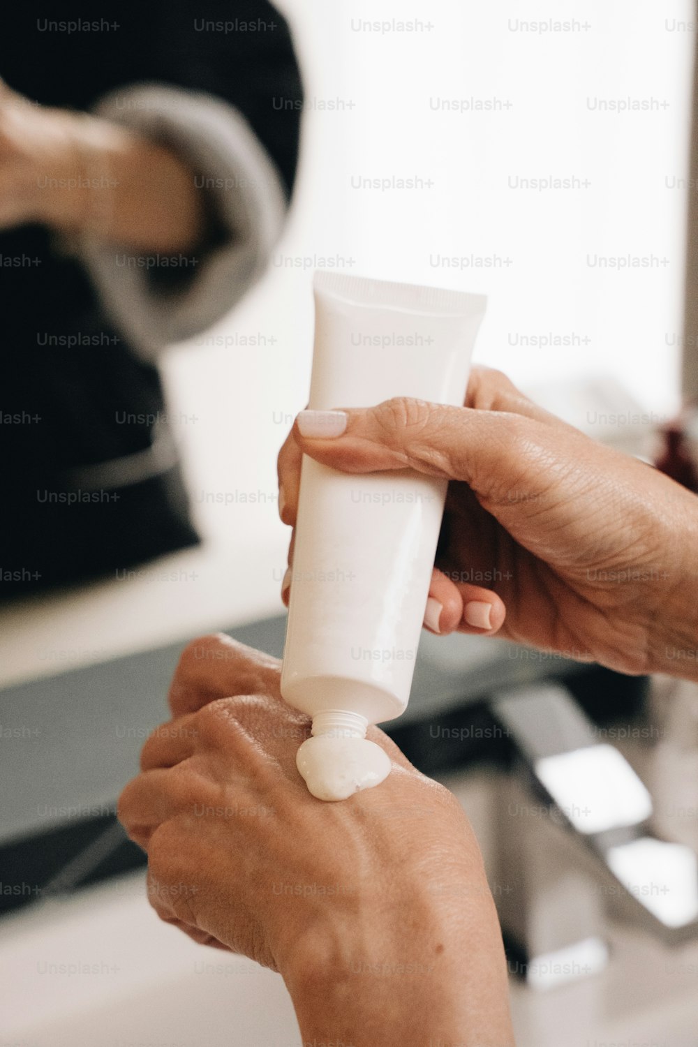 a person holding a tube of cream in their hand