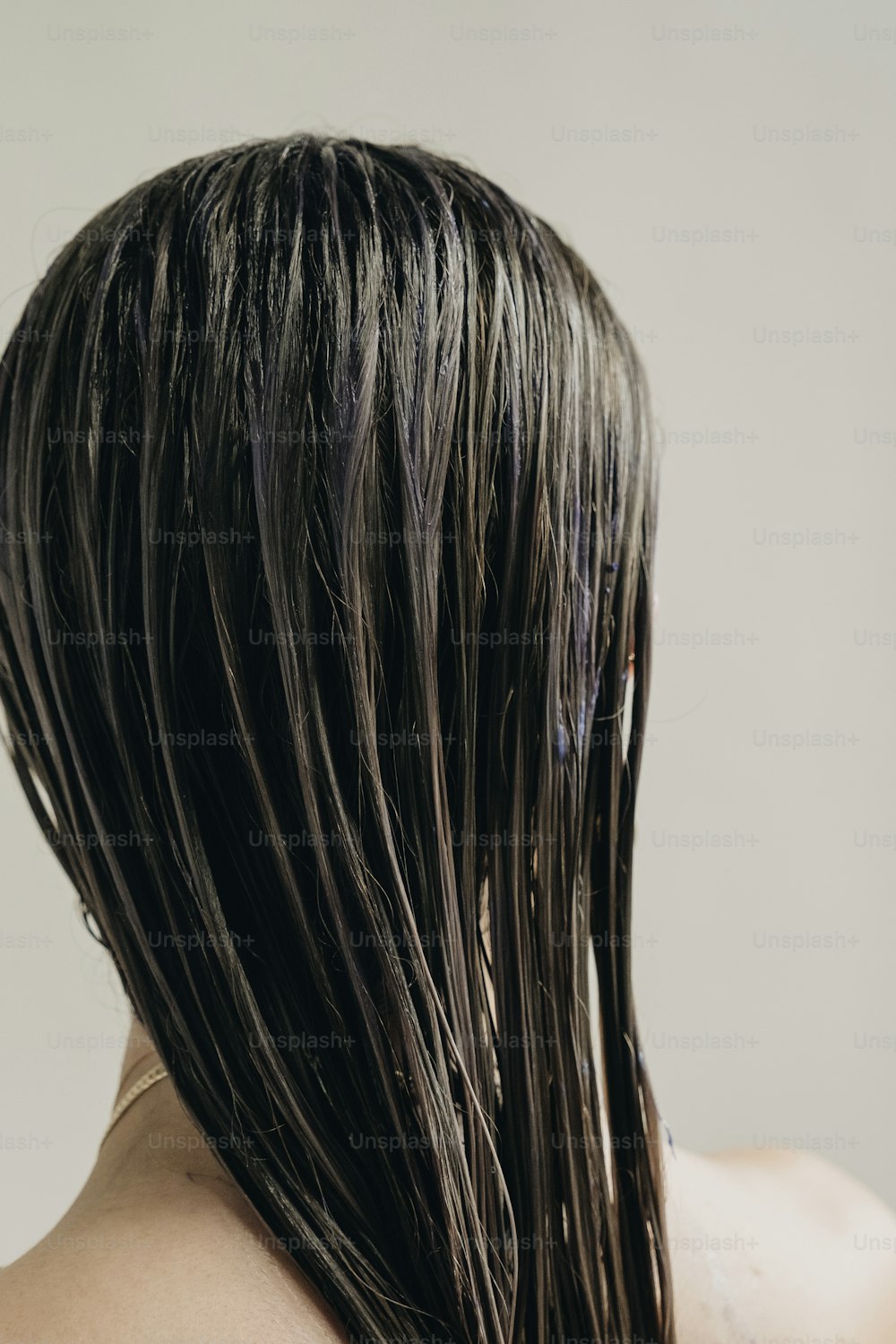 a parte de trás da cabeça de uma mulher com o cabelo molhado