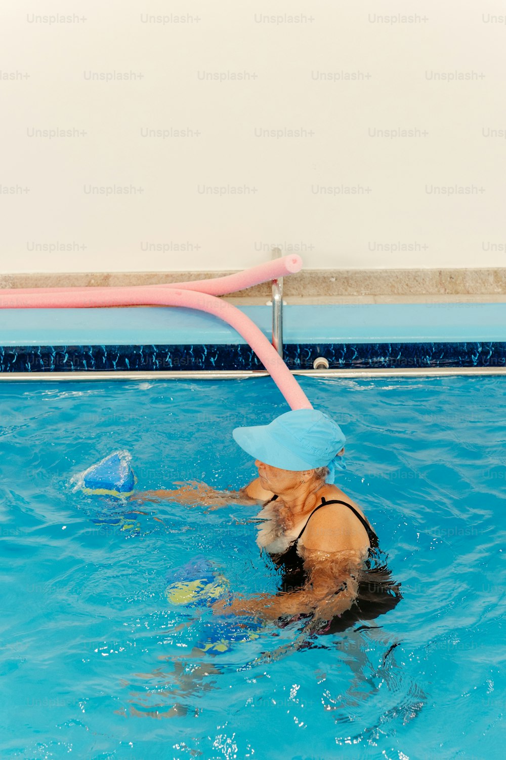 a dog in a swimming pool wearing a hat