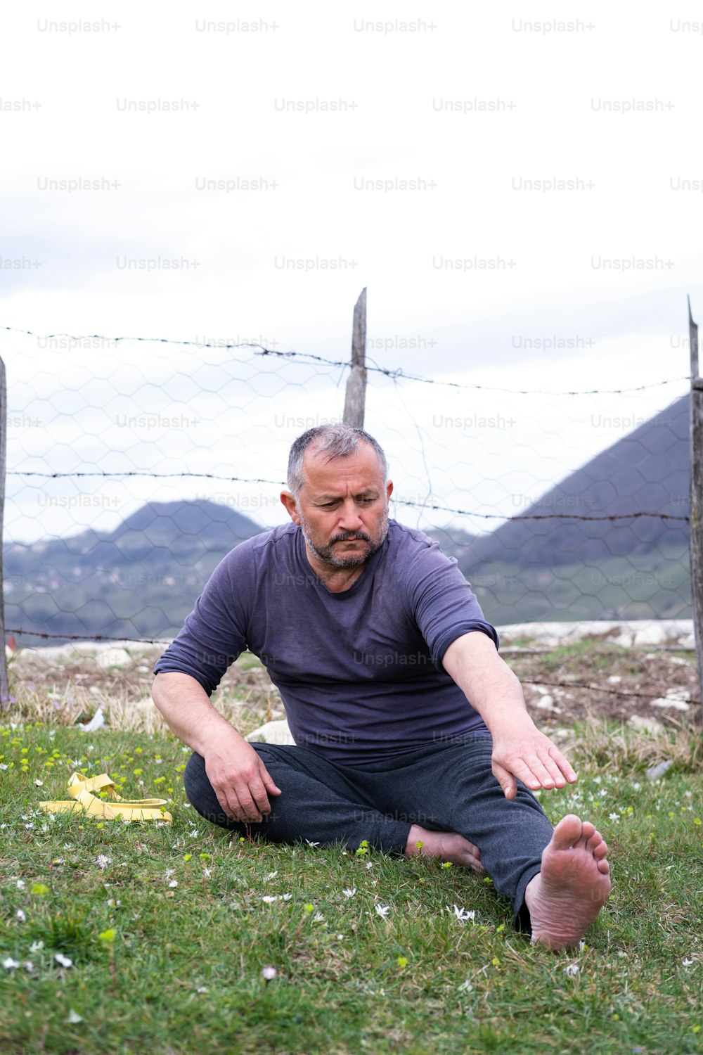 Ein Mann, der auf dem Boden auf einem Feld sitzt