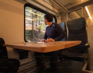 Un homme assis à une table dans un train