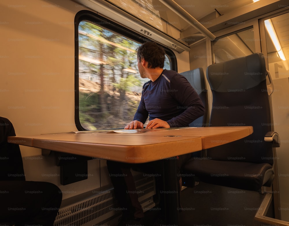 a man sitting at a table on a train