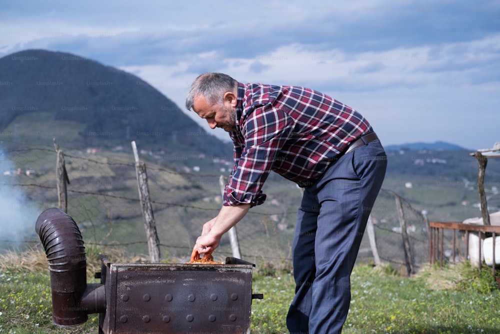 Un uomo sta grigliando carne su una griglia all'aperto
