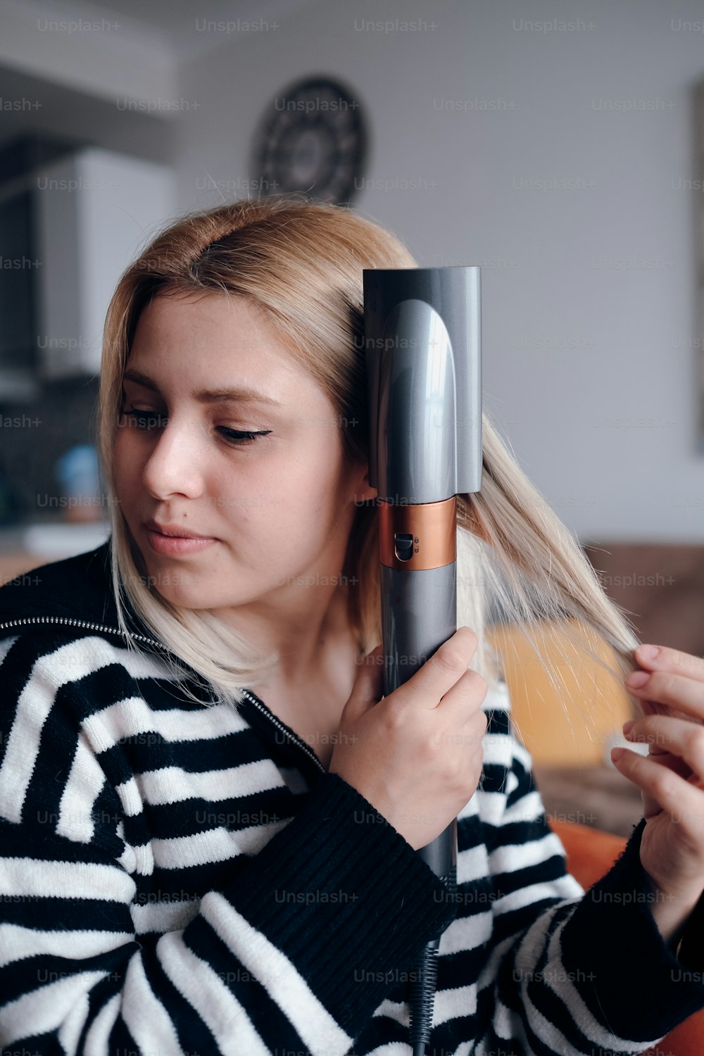 a woman blow drying her hair with a hair dryer