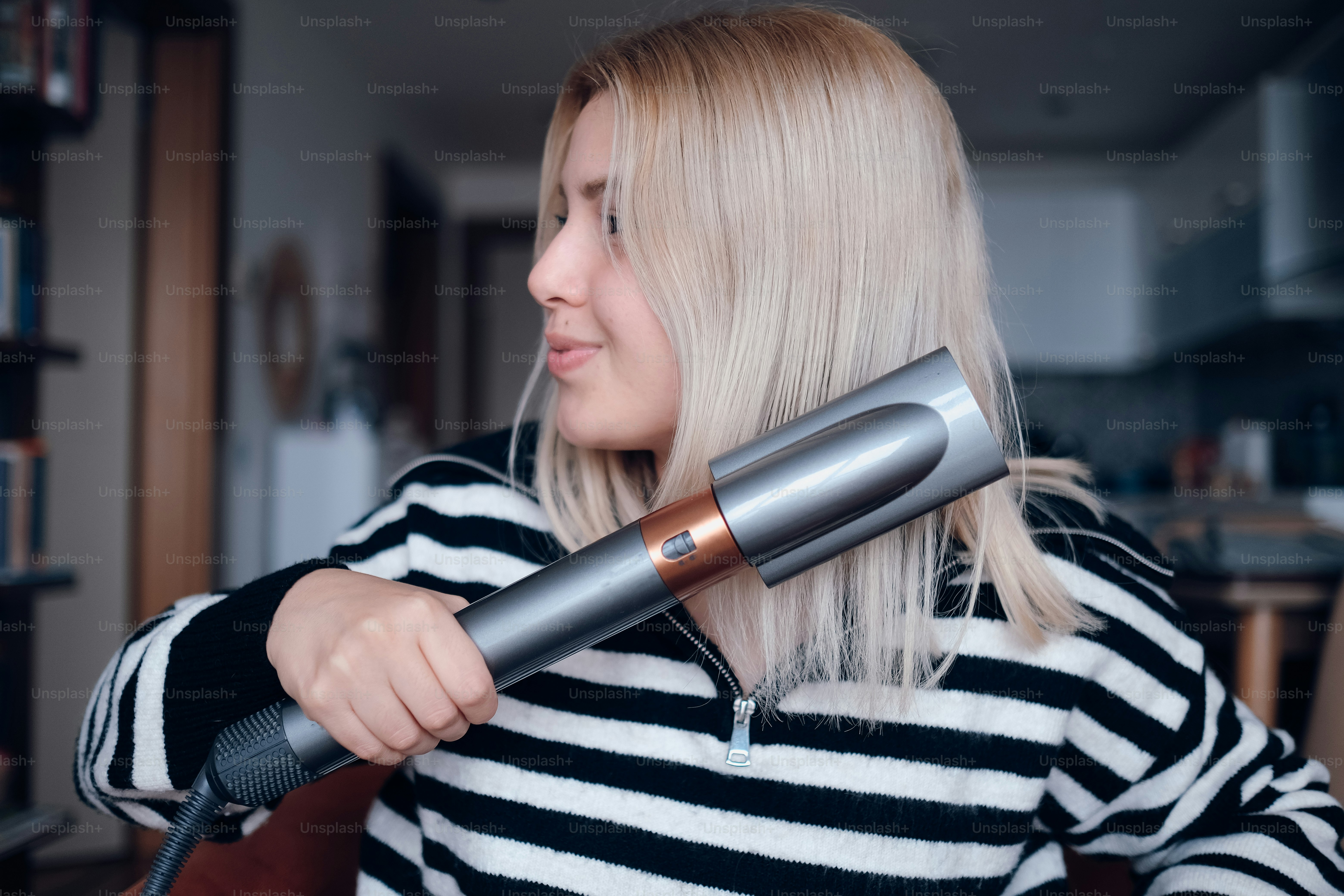 a woman blow drying her hair with a hair dryer