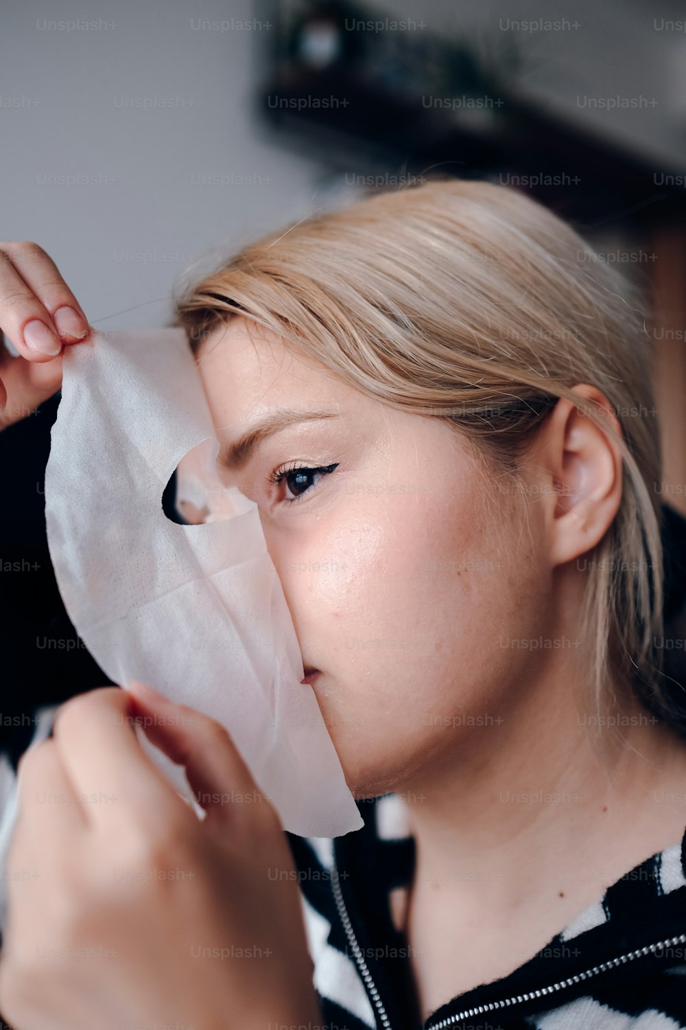 Una mujer sosteniendo un pedazo de pañuelo sobre su cara