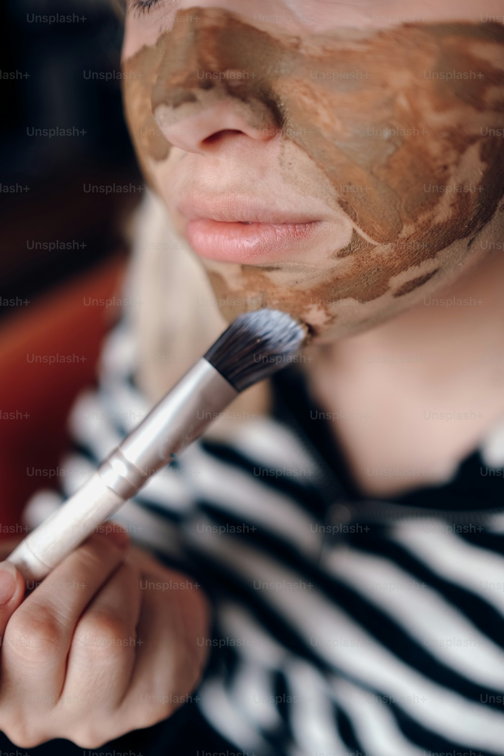 une femme avec un masque facial tenant une brosse