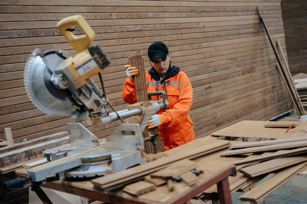 Un hombre con una chaqueta naranja trabajando en una máquina