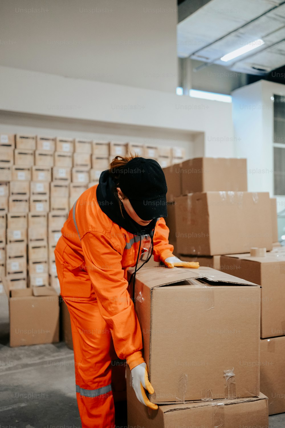 주황색 점프수트를 입은 남자가 상자에서 일하고 있다