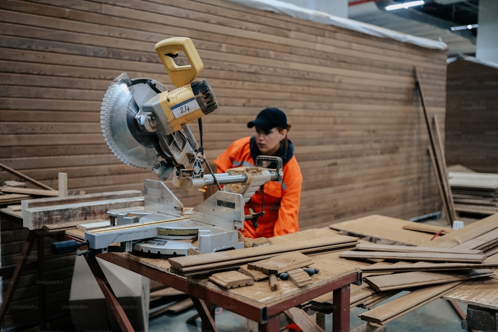 um homem em uma jaqueta laranja trabalhando em uma máquina