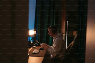 Un hombre sentado en un escritorio frente a una computadora
