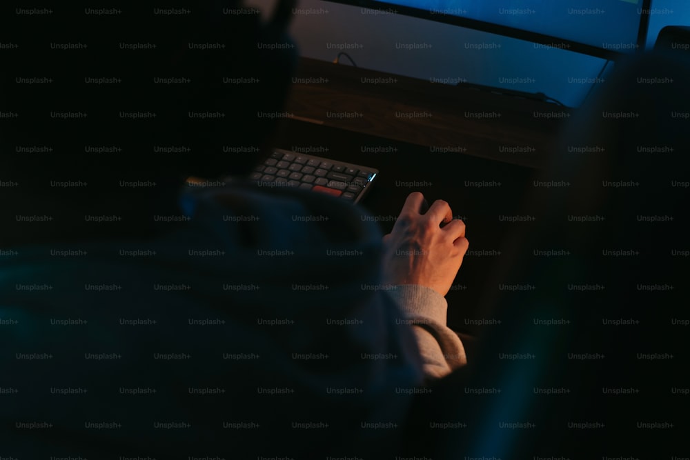 a person typing on a keyboard in front of a monitor