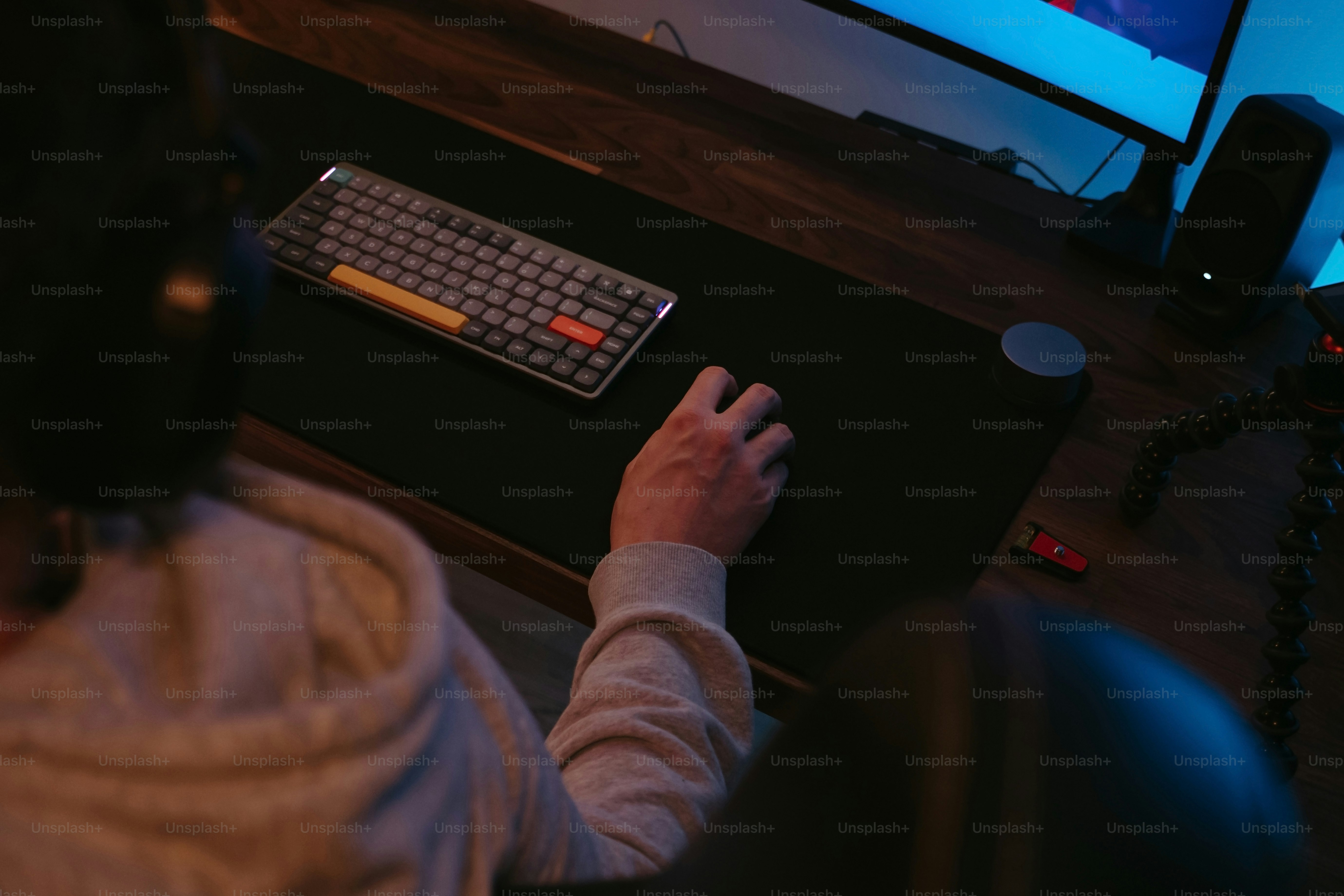a person sitting at a desk with a keyboard and mouse