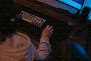 a person sitting at a desk with a keyboard and mouse