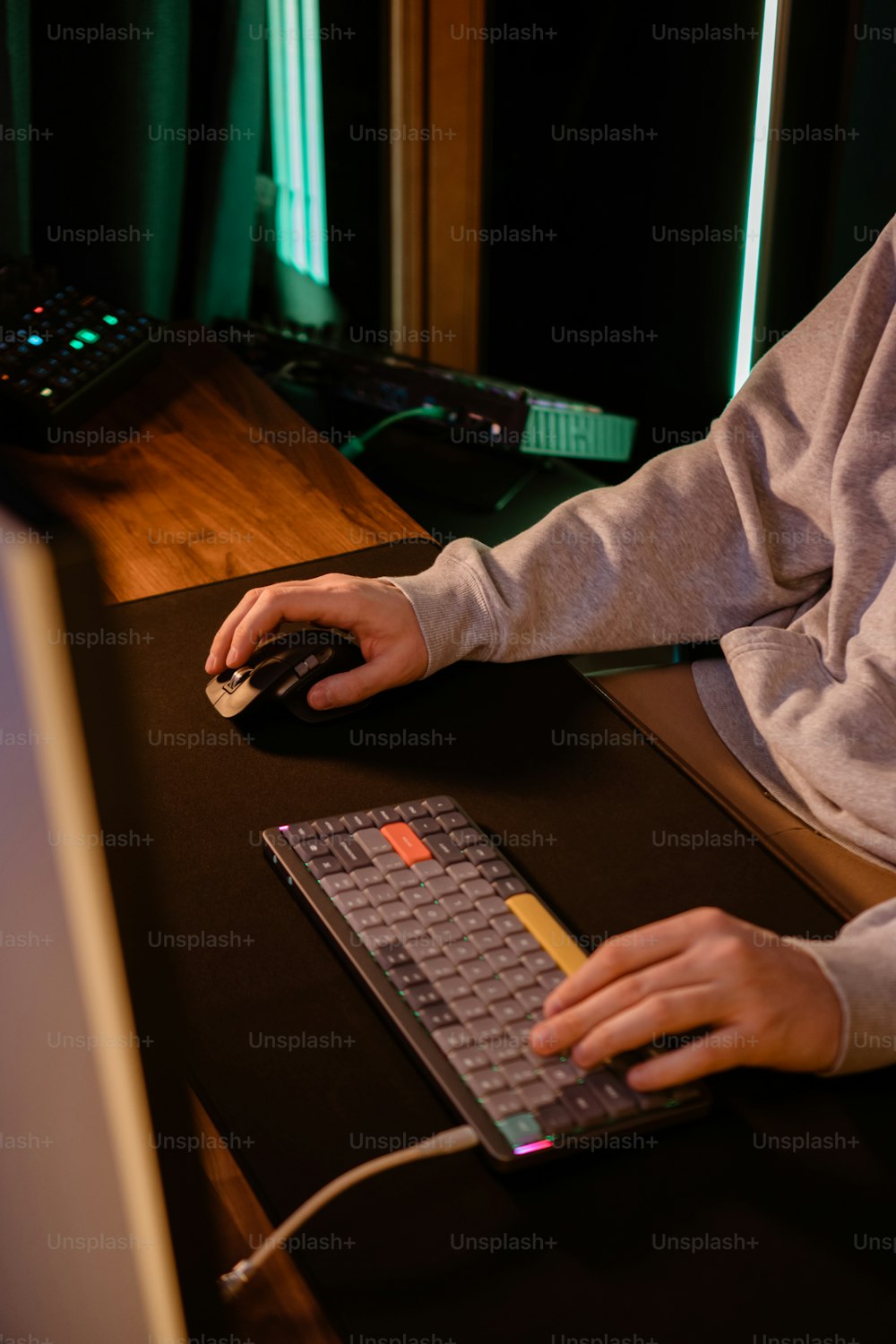 a person sitting at a desk with a mouse and keyboard