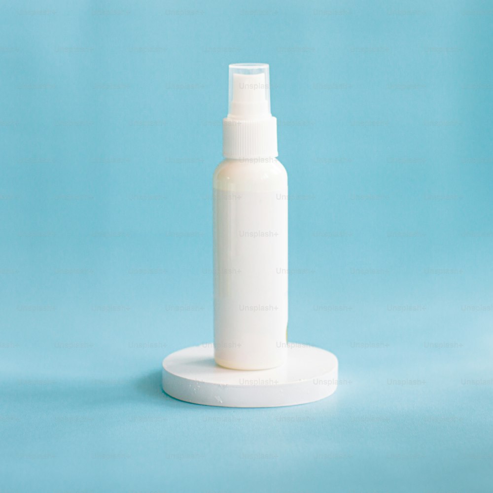 a white bottle on a white base on a blue background