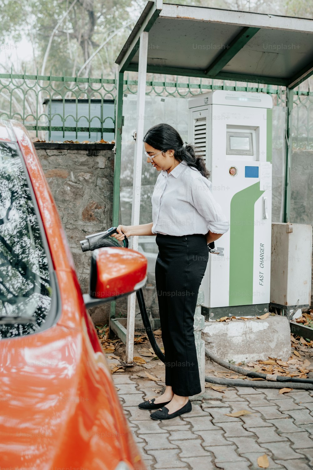 uma mulher enchendo seu carro em um posto de gasolina
