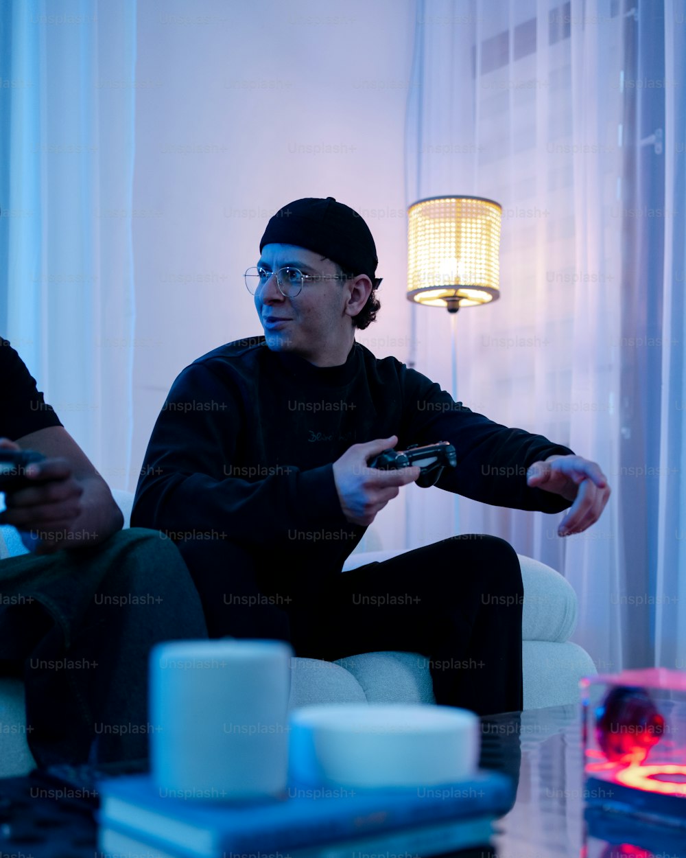 two men sitting on a couch playing a video game