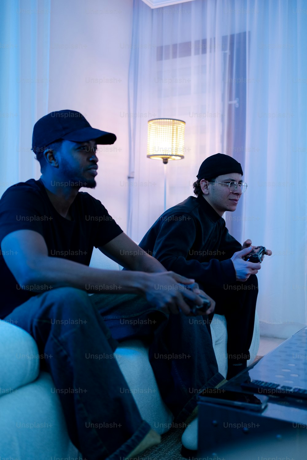 dois homens sentados em um sofá jogando um videogame