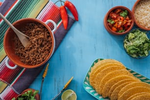 a table topped with bowls of food and tortillas