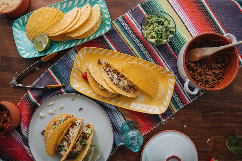une table surmontée d’assiettes de tacos et de bols de salsa