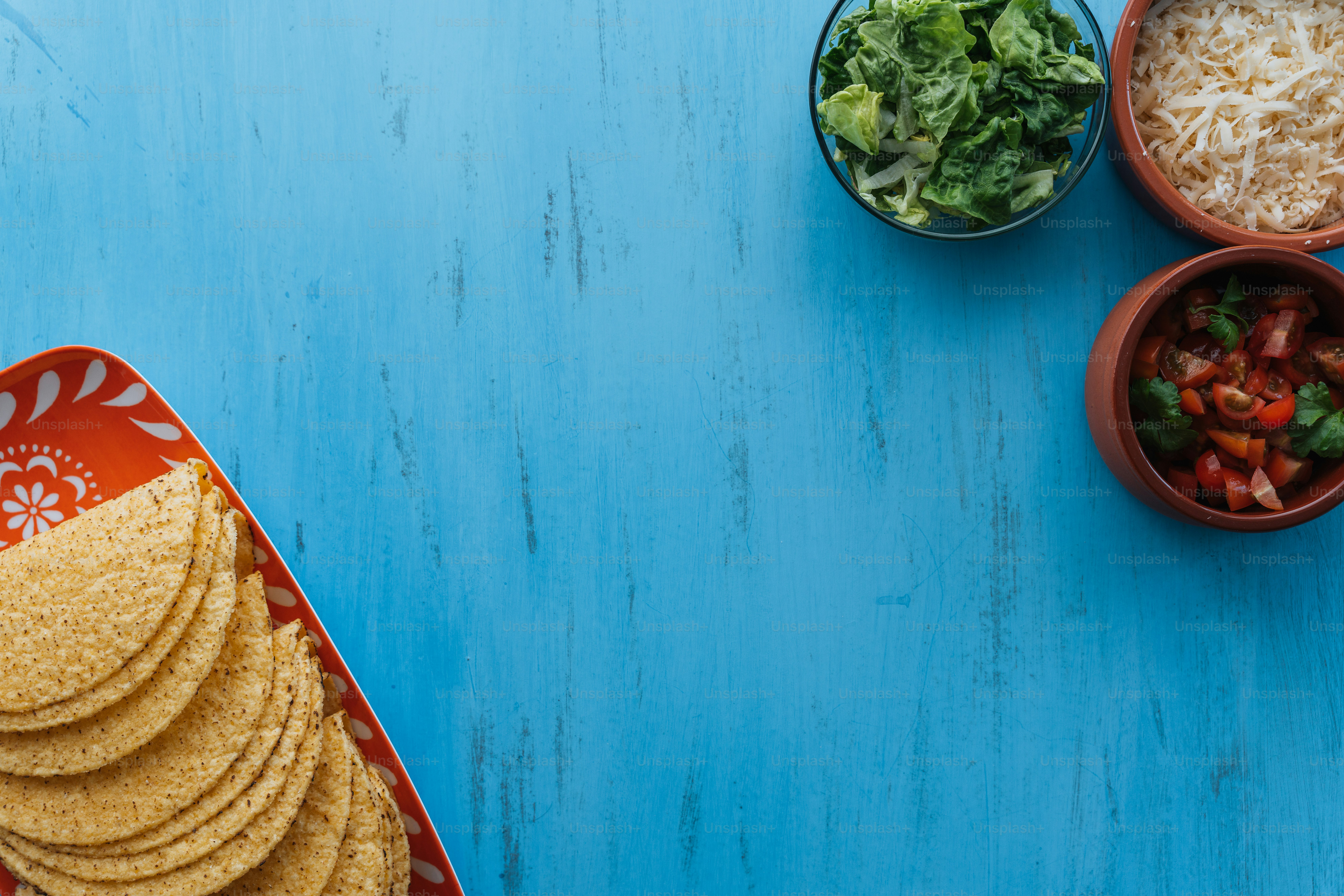 a plate of tortillas, a bowl of salad and a bowl of rice