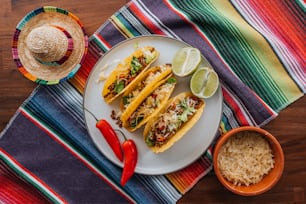 Trois tacos sur une assiette avec un côté de riz