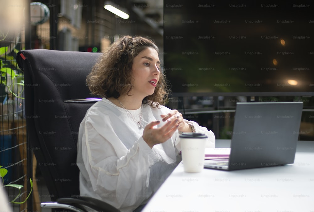 Una donna seduta a una scrivania davanti a un computer portatile