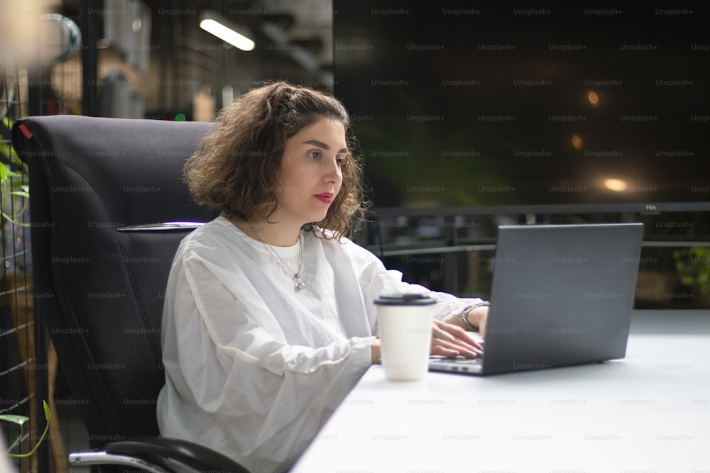 Una donna seduta a una scrivania con un computer portatile