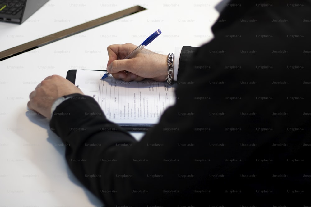 a person sitting at a desk writing on a piece of paper