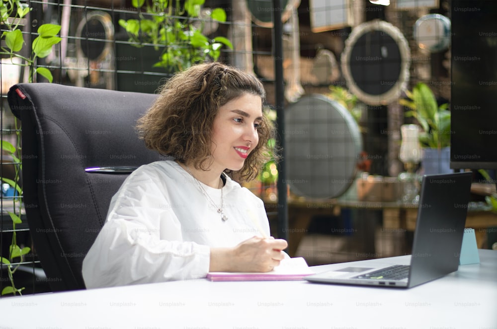 Une femme assise à un bureau avec un ordinateur portable