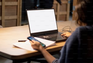 a woman sitting at a table with a laptop computer