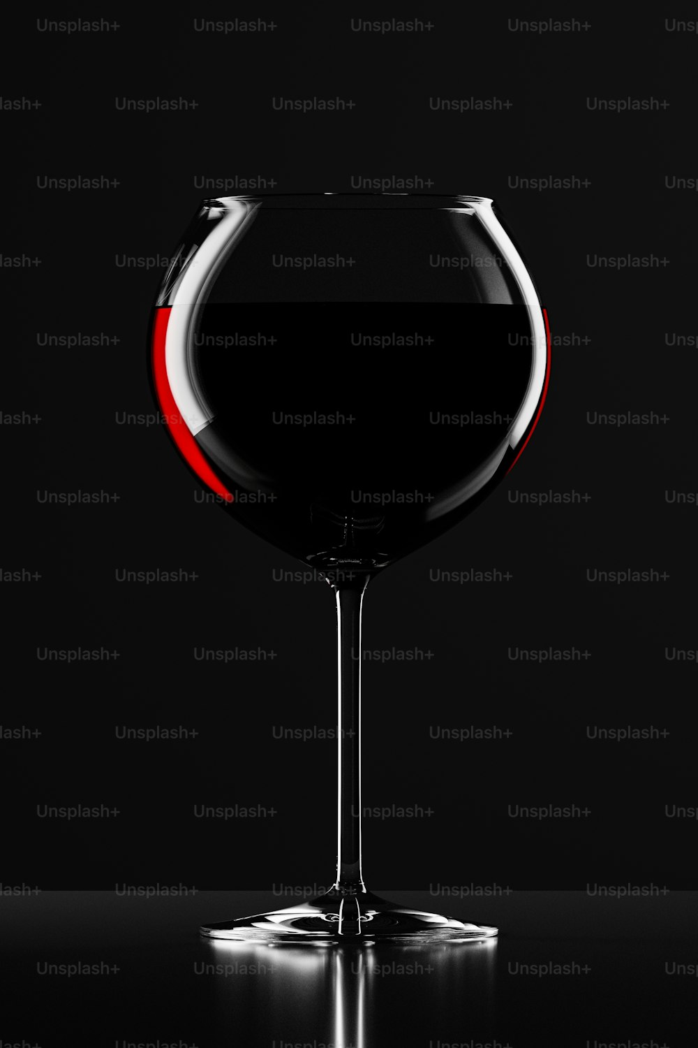 ein Glas Rotwein auf einem schwarzen Tisch