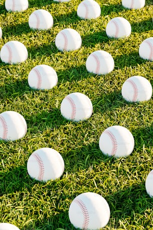 a field full of white baseballs laying on top of green grass