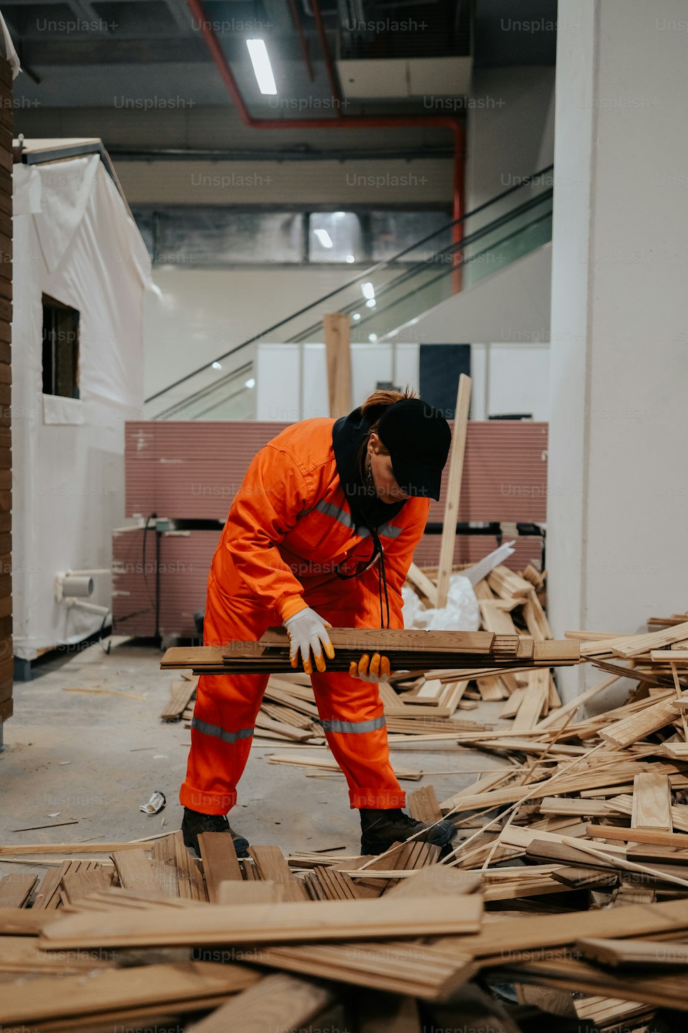 a man in an orange jumpsuit working on a piece of wood