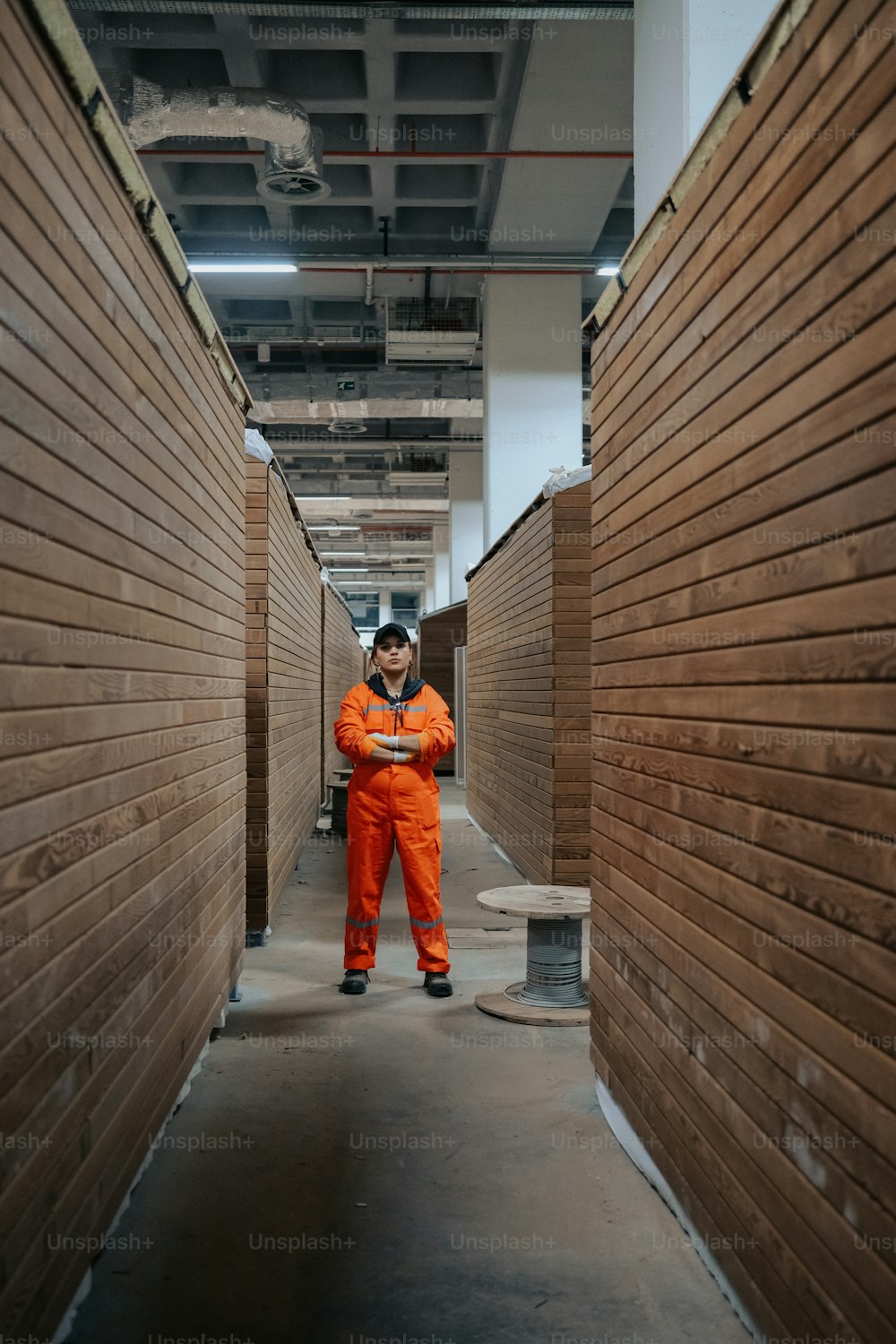 um homem em um macacão laranja de pé em um corredor