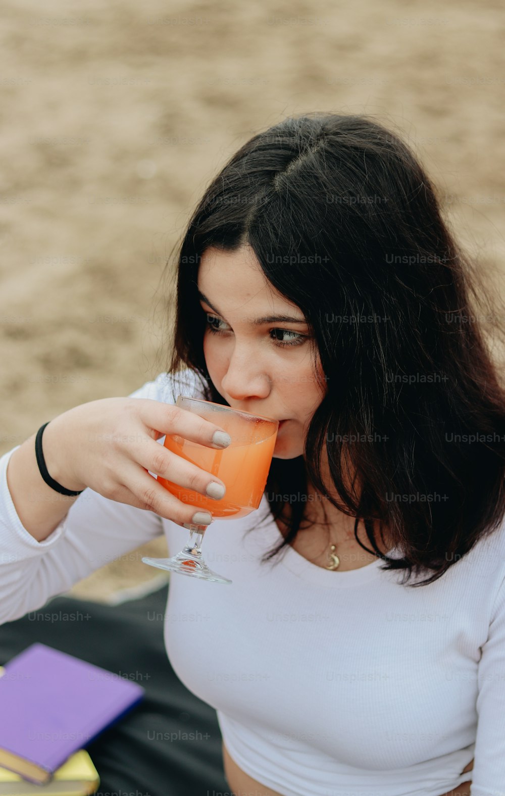 a woman in a white shirt drinking a drink