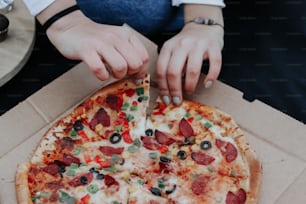 a person cutting a pizza with a knife