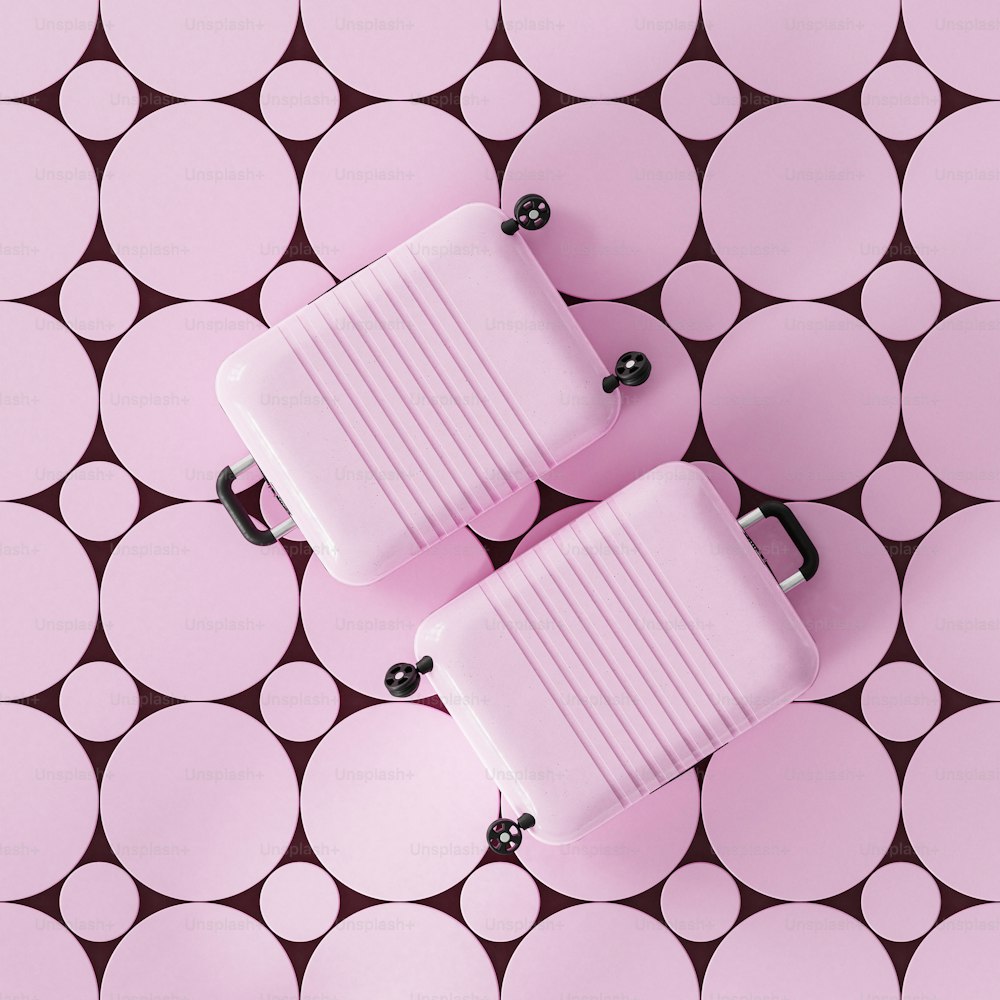 Due bagagli seduti sopra una superficie rosa