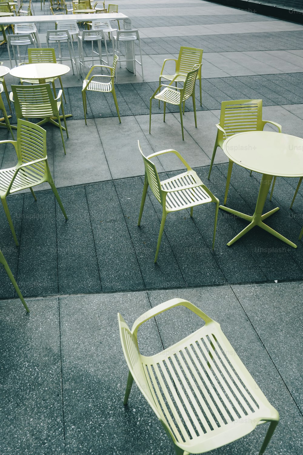 eine Reihe von Stühlen und Tischen auf einem Bürgersteig